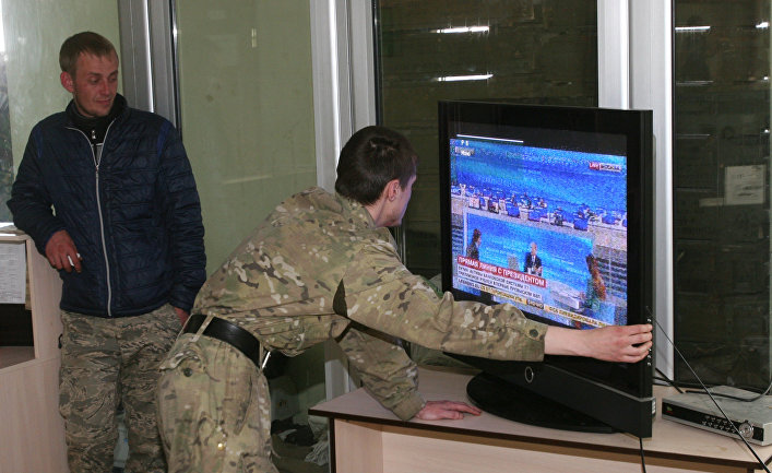 Ополченцы ДНР настраивают телевизор для просмотра ежегодной специальной программы «Прямая линия с Владимиром Путиным»