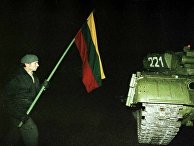 Один из протестующих с флагом около советского танка. Ночь 13 января 1991 года Один из протестующих с флагом около советского танка. Ночь 13 января 1991 года