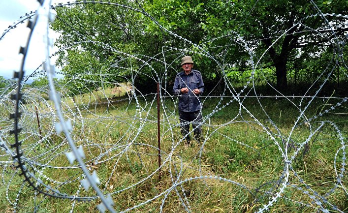 Местный житель возле колючей проволоки на границе Грузии и Южной Осетии