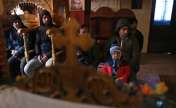 Сирийские беженцы-католики на службе в православной церкви в деревне Идомени, Греция