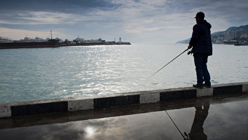 Рыбак на набережной Ялты