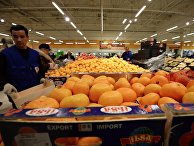 Продавец у прилавка с мандаринами из Турции в торговом зале гипермаркета "Глобус" Продавец у прилавка с мандаринами из Турции в торговом зале гипермаркета "Глобус"