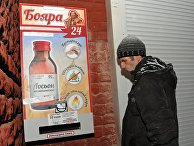 Мужчина у автомата по продаже спиртосодержащего средства с боярышником Мужчина у автомата по продаже спиртосодержащего средства с боярышником