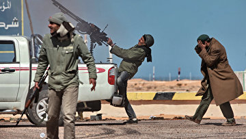 Боец оппозиции стреляет из пулемета в истребитель в городе Рас-Лануф