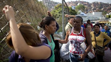 Люди стоят в очереди, чтобы купить продукты в Каракасе