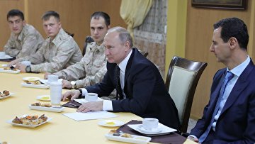 Президент РФ Владимир Путин и президент Сирийской Арабской Республики Башар Асад во время общения с военнослужащими авиабазы Хмеймим в Сирии