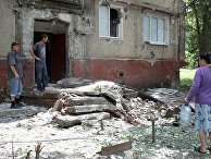 Жители во дворе жилого дома, пострадавшего в результате обстрела, в поселке Горловка Донецкой области Жители во дворе жилого дома, пострадавшего в результате обстрела, в поселке Горловка Донецкой области