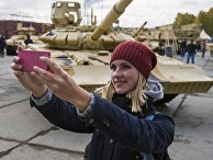 Посетитель фотографируется на фоне танка Т-90А на 10-й международной выставке Russia Arms Expo