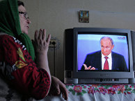 Жительница деревни Фрунзе Омской области смотрит телетрансляцию пресс-конференции президента России Владимира Путина. Жительница деревни Фрунзе Омской области смотрит телетрансляцию пресс-конференции президента России Владимира Путина.
