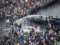 Разгон демонстрантов водометом перед зданием правительства в Бухаресте
