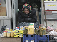 Пожилая женщина торгует на улице в Киеве Пожилая женщина торгует на улице в Киеве