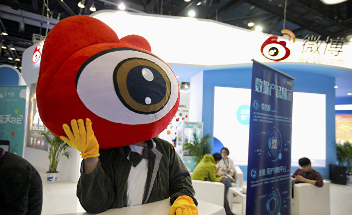 Сотрудник на стенде китайского сайта микроблогов Sina Weibo