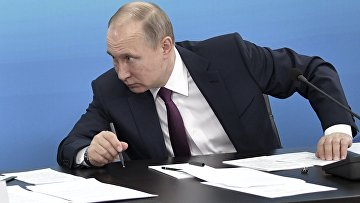 Президент России Владимир Путин работает за столом Президент России Владимир Путин работает за столом