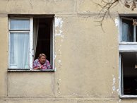 Женщина в окне пятиэтажного жилого дома Женщина в окне пятиэтажного жилого дома