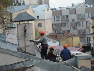 Рабочие-строители на крыше здания в Москве Рабочие-строители на крыше здания в Москве