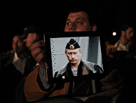 Протестующие с фотографией президента России Владимира Путина во время акции протеста у здания кипрского парламента Протестующие с фотографией президента России Владимира Путина во время акции протеста у здания кипрского парламента