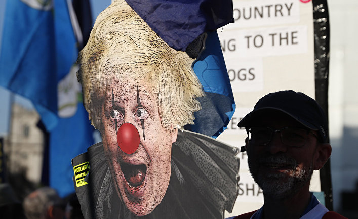 Сторонник ЕС с плакатом, изображающим Бориса Джонсона в виде клоуна во время демонстрации у Вестминстерского дворца в Лондоне