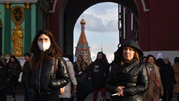 Люди проходят через Воскресенские ворота, ведущие на Красную площадь, в Москве