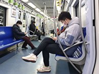 Пассажиры пекинского метро в медицинских масках Пассажиры пекинского метро в медицинских масках