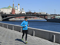 Мужчина бежит по Пречистенской набережной в Москве Мужчина бежит по Пречистенской набережной в Москве