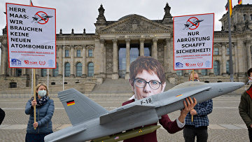 Участник анти-ядерной акции протеста в маске министра обороны Германии Аннегрет Крамп-Карренбауэр в Берлине