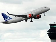 Самолет SAS на взлете в аэропорту Самолет SAS на взлете в аэропорту