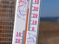 +32 градуса Цельсия на солнце показывает термометр на стене зимнего передвижного рыбацкого домика на берегу реки Енисей в окрестностях Красноярска +32 градуса Цельсия на солнце показывает термометр на стене зимнего передвижного рыбацкого домика на берегу реки Енисей в окрестностях Красноярска