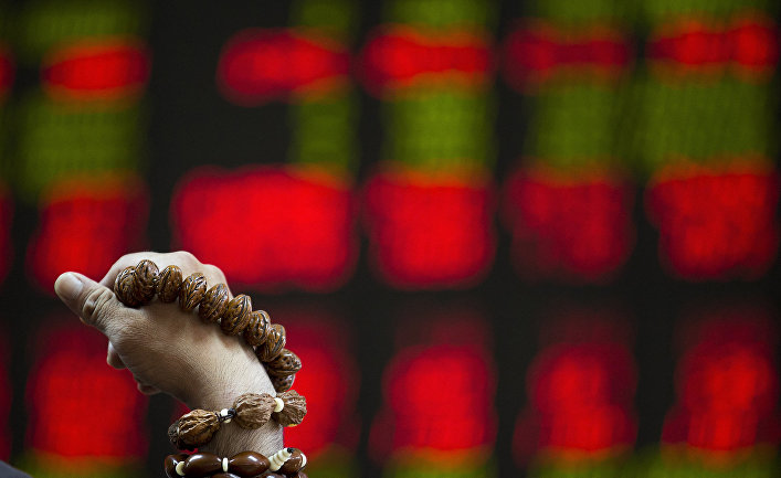 Мужчина перебирает четки на фондовой бирже в Пекине