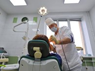 Хирург-стоматолог во время приема пациента Хирург-стоматолог во время приема пациента