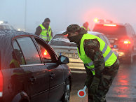 Полицейские проверяют автомобили на блокпосту в Вильнюсе Полицейские проверяют автомобили на блокпосту в Вильнюсе