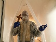 Священник в защитном костюме посещает пациентов коронавирусного отделения больницы во Львове, Украина Священник в защитном костюме посещает пациентов коронавирусного отделения больницы во Львове, Украина