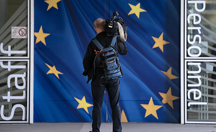 Журналист у входа в здание Европейской комиссии в Брюсселе