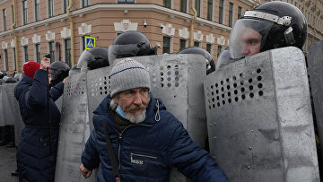Сотрудники правоохранительных органов и участники несанкционированной акции сторонников Алексея Навального у здания Законодательного Собрания в Санкт-Петербурге
