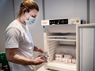 Медработник убирает вакцину от AstraZeneca на хранение в связи с приостановкой вакцинации, Копенгаген, Дания Медработник убирает вакцину от AstraZeneca на хранение в связи с приостановкой вакцинации, Копенгаген, Дания