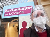 Девушка в защитной маске возле пункта вакцинации от коронавируса в ГУМе в Москве Девушка в защитной маске возле пункта вакцинации от коронавируса в ГУМе в Москве