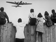 1 августа 1948. Дети из Западного Берлина смотрят, как в аэропорту Темпельхоф заходит на посадку самолет с продовольствием 1 августа 1948. Дети из Западного Берлина смотрят, как в аэропорту Темпельхоф заходит на посадку самолет с продовольствием