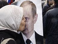 Сирийская женщина целует портрет президента РФ Владимира Путина Сирийская женщина целует портрет президента РФ Владимира Путина